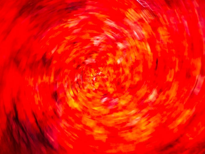 Intentional camera movement on fall foliage. The photo looks like a red whirlwind