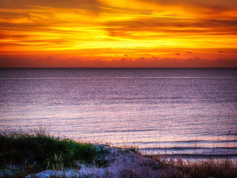 A beautiful warm orange sunset over the ocean at Cape San Blas, Florida