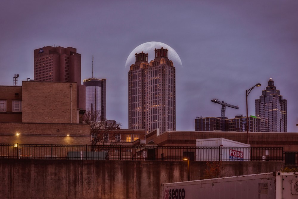 A creative photo edit showing a moonrise just behind 191 Peachtree Tower in Atlanta