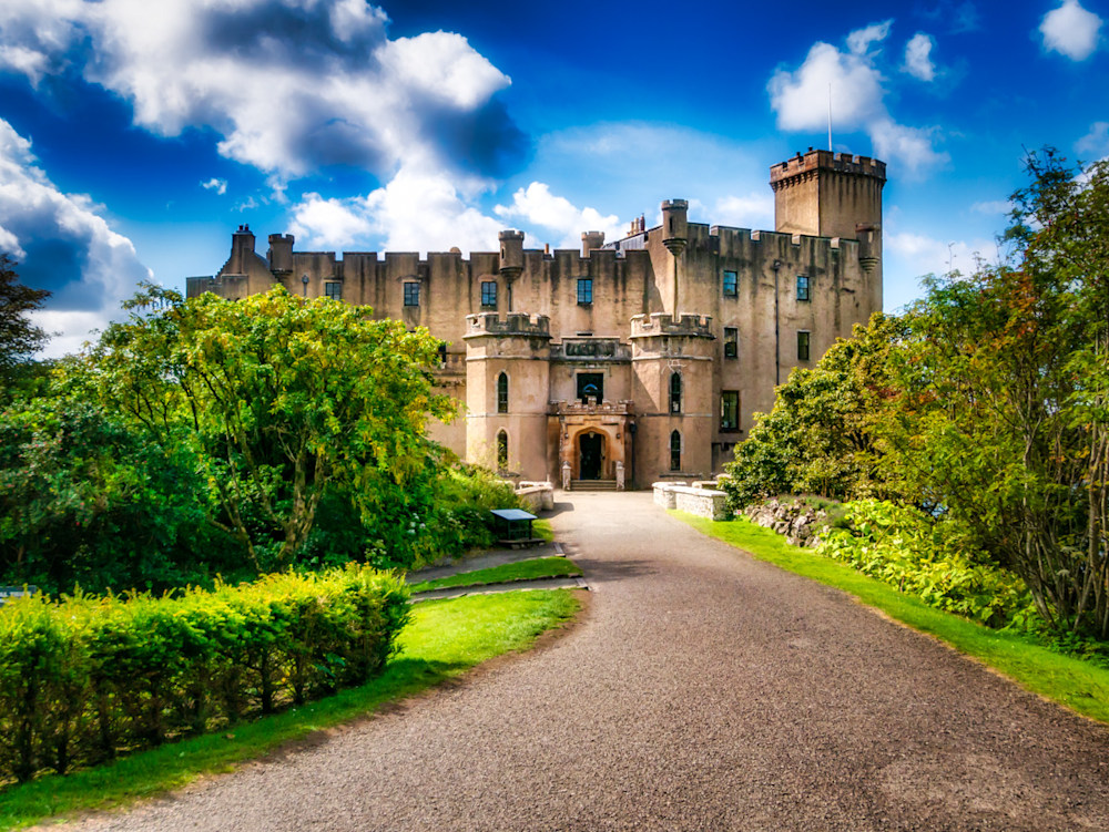 Dunvegan Castle in Scotland on a bright blue-sky day with puffy white clouds