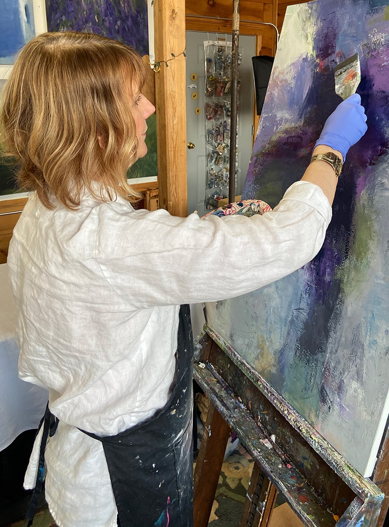 Photo of Dawn Boyer painting in her studio