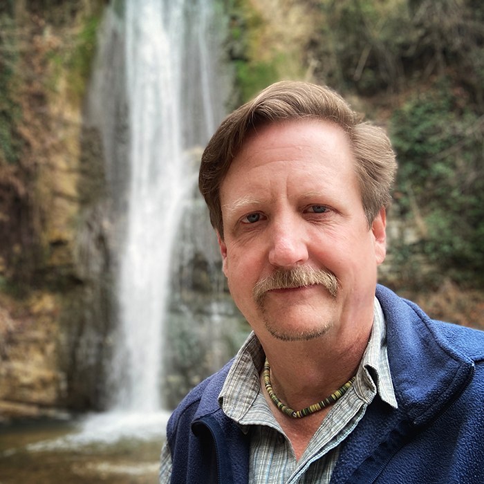 Photo of Sean Weaver by a waterfall
