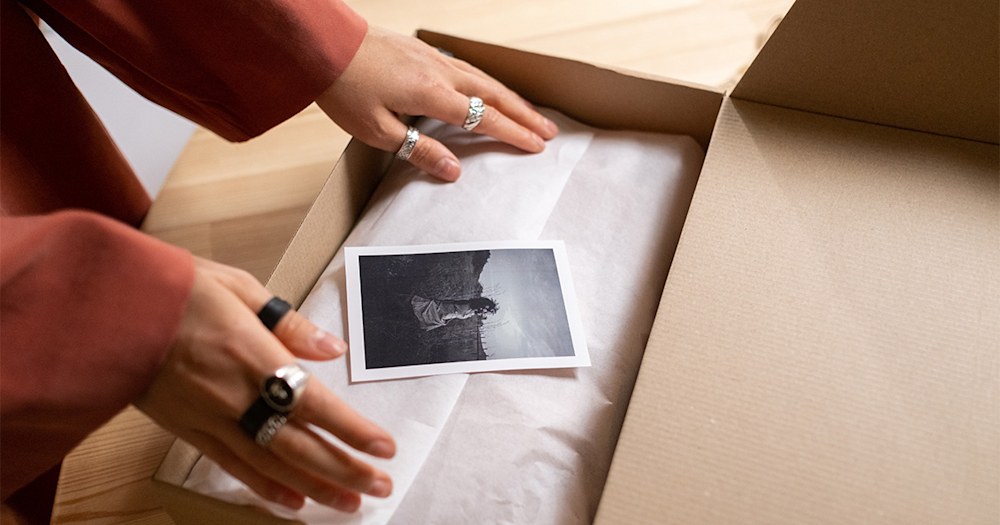 Placing photos in a box. Cover image for the blog "Preserving Memories"