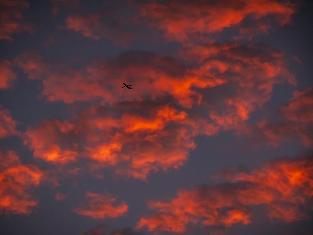 An Atlanta photographer capturing beautiful pink and orange clouds and an airplane