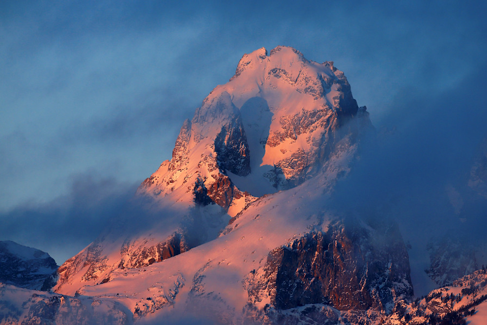 Teton peak glowing at sunrise, partially veiled in alpine mist — a moment of wilderness worship in the high country