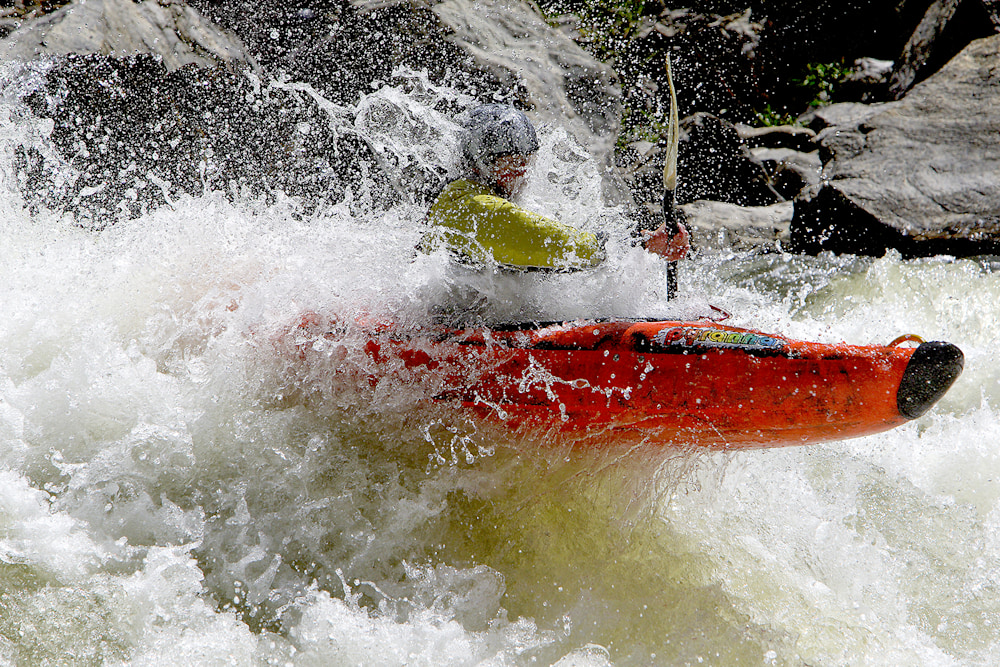 Kayak bow slicing through a river current, guiding the trajectory downstream