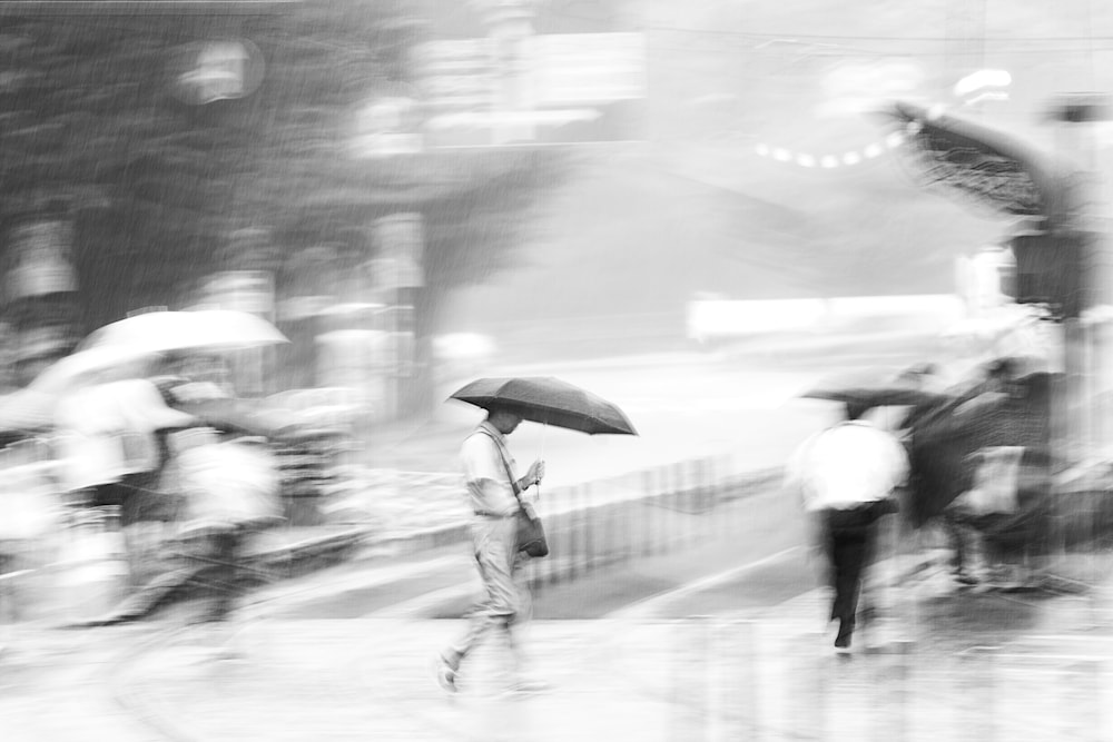 Figure walking calmly with an umbrella through a crowded, rain-soaked Kumamoto street as blurred pedestrians rush in multiple directions.