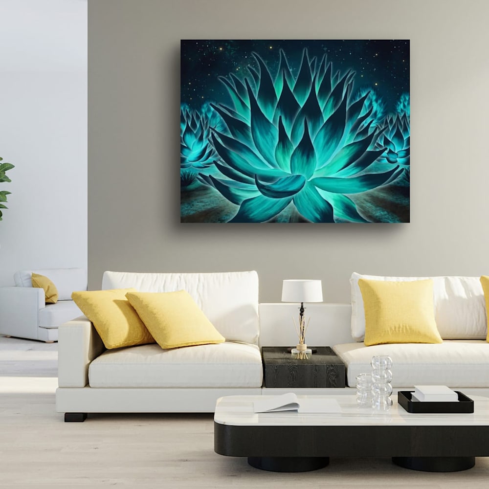 Large neon desert agave print in teal and emerald tones displayed above a white modern sofa with yellow pillows in a bright contemporary living room.