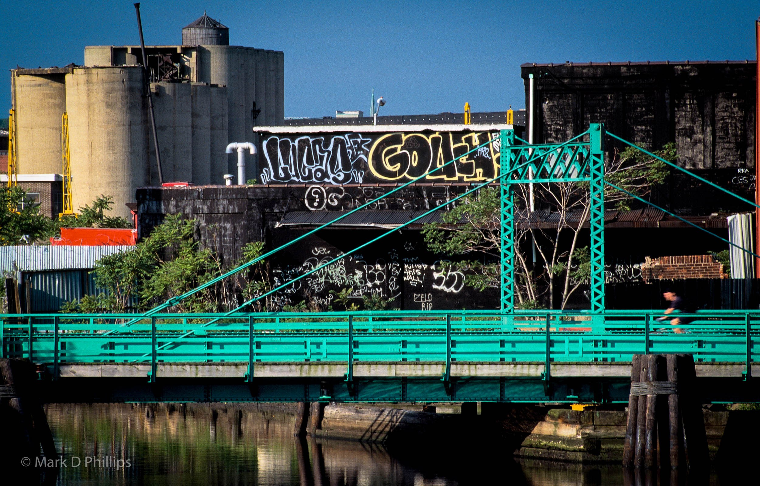 
        <div class='title'>
          Gowanus: Lucas Gouch, Carroll Bridge
        </div>
       
        <div class='description'>
          My earliest graffiti picture from the Gowanus Canal was widely published. The signature looming over the Carroll Street Bridge was completed in 1998 by by Lucas Gouch, the artist. The year is in the HR at the end of his name. An effort had begun to clean the waterway and several of my images, including this one, appeared in the New York Times. ©Mark D Phillips
        </div>
      