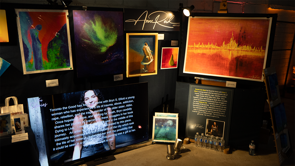Booth section with story panel about Bryn S. Elliott beside featured works